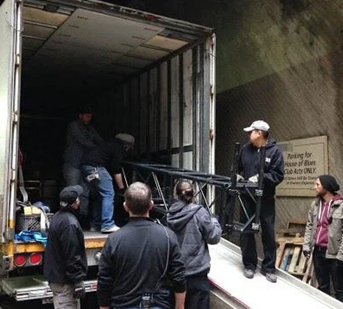PTES stagehands unloading truss from a truck at the loading dock